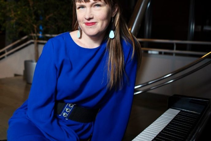 Kati Toikka istuu pianon ääressä.
