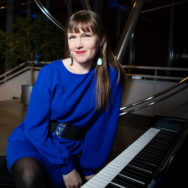Kati Toikka istuu pianon ääressä.